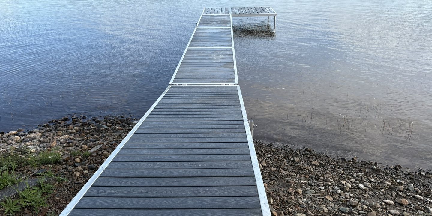 A dock decked in recycled plastic lumber running out into a lake in Ontario