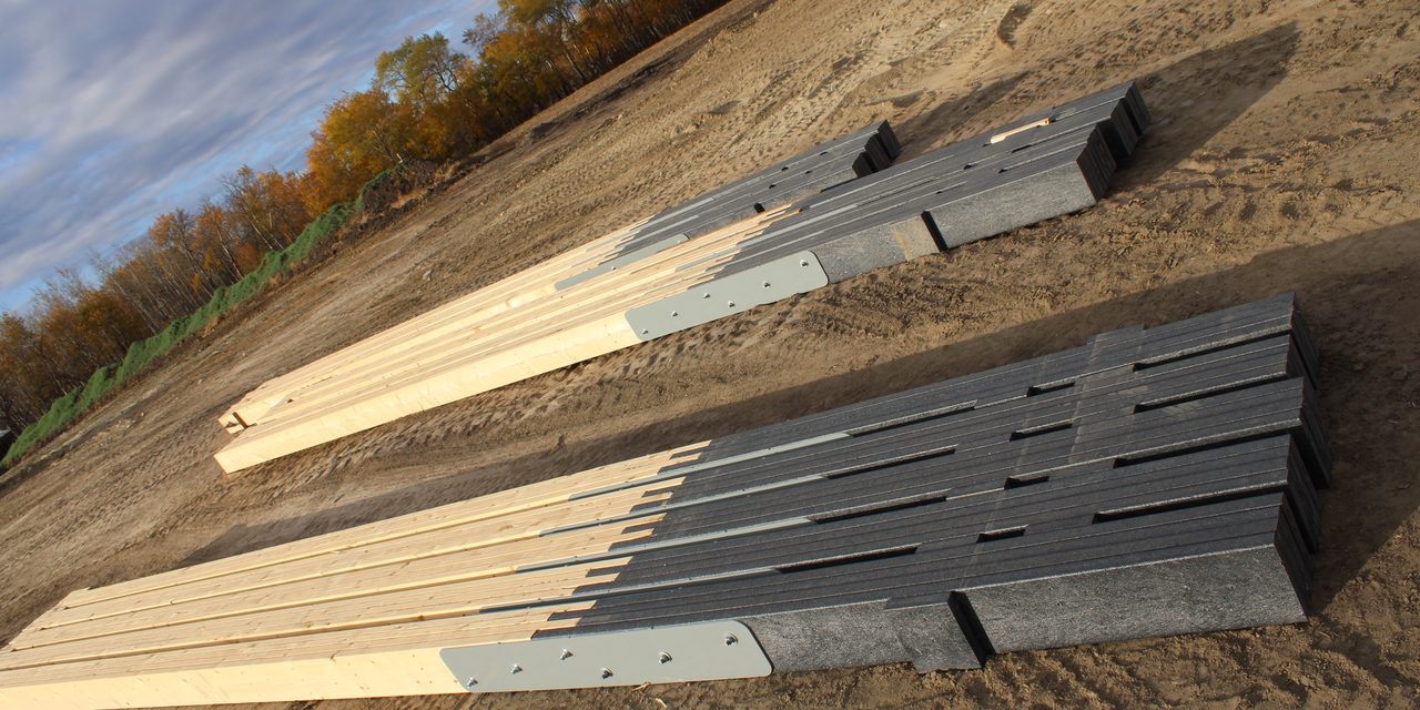 Eco Column recycled plastic bases bolted to timber posts, laid out in rows on a cleared build site