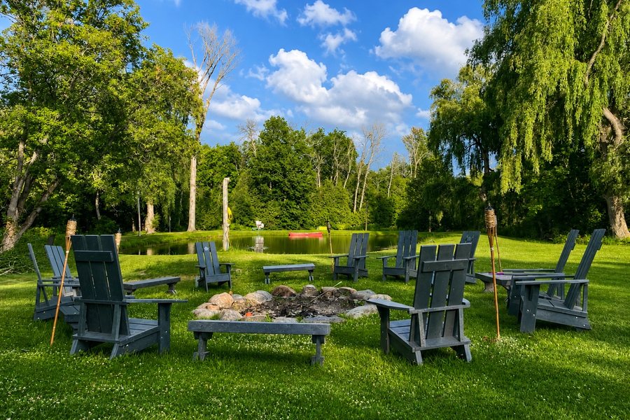 Recycled plastic chairs set around a fire pit on a lawn