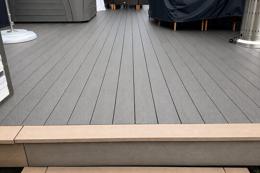 A backyard deck in grey recycled plastic lumber with a hot tub, in Georgina, Ontario