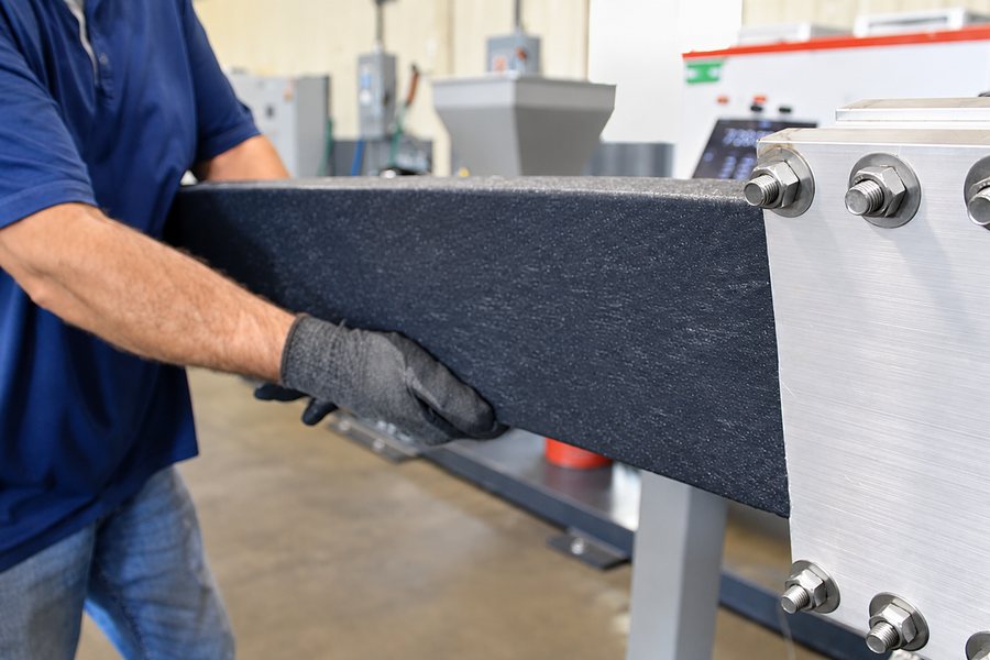 Recycled HDPE being extruded into plastic lumber boards